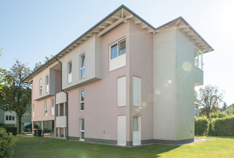 Dreigeschossiges Wohnhaus mit Loggien über einer Rasenfläche