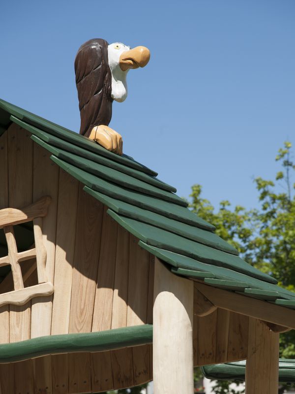 Dach des Spielhauses mit geschnitzter Vogelfigur