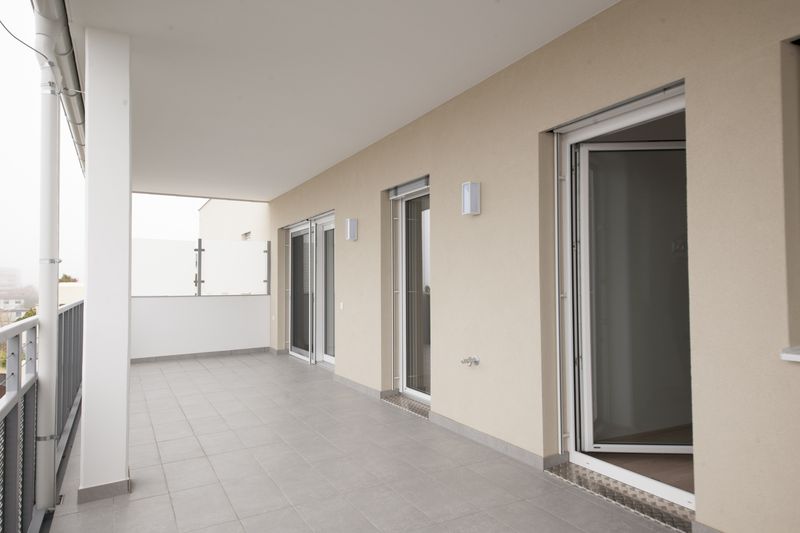 Loggia mit Fliesenboden und Fenstertüren