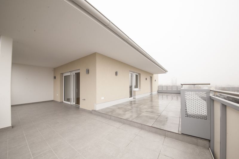 Dachterrasse vor einer Fassade mit Glasschiebetüren