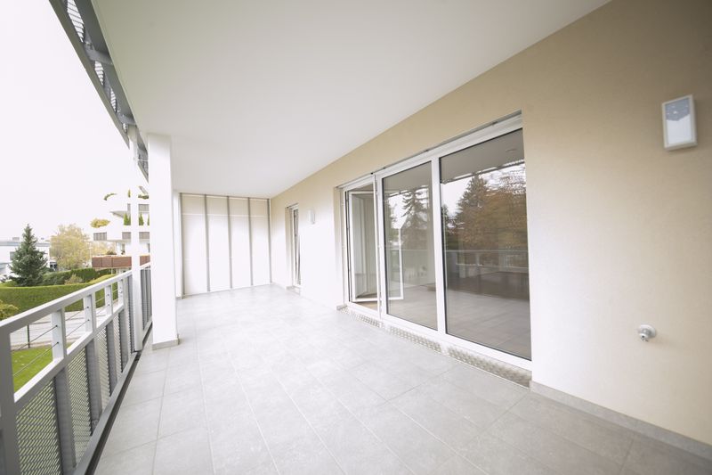 Loggia mit großen Glasschiebetüren und Blick in den Garten