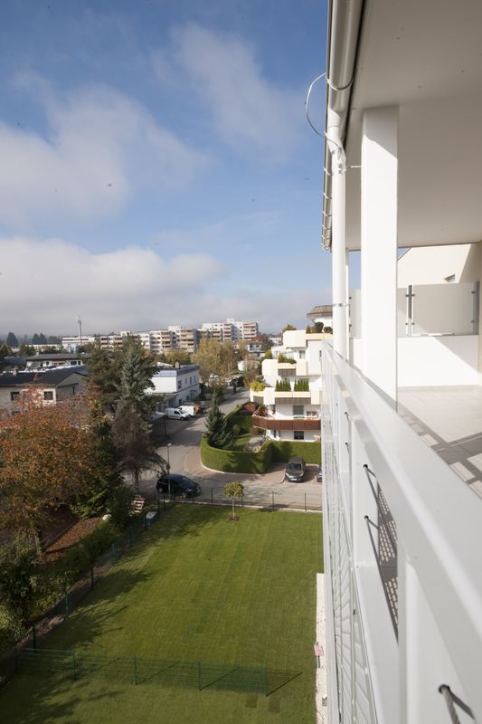 Blick von einer Loggia auf den begrünten Innenhof